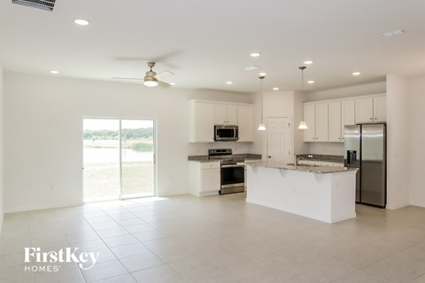 A spacious kitchen with a refrigerator, microwave, and oven.