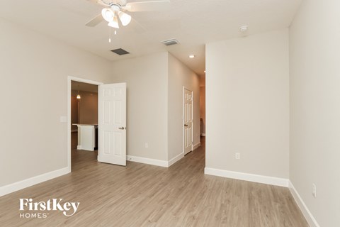 a spacious living room with white walls and wood flooring
