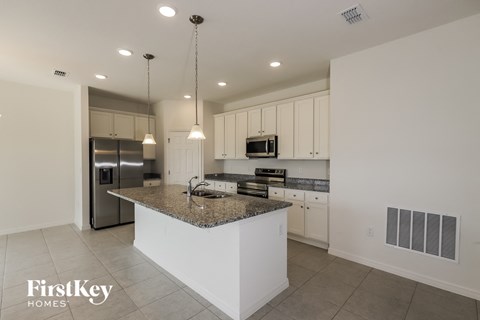 a kitchen with white cabinets and a granite counter top