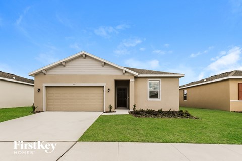 a beige house with a lawn and a garage door