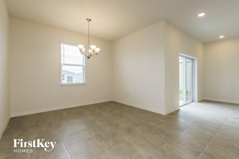 the living room and dining room are spacious and lighted by a chandelier