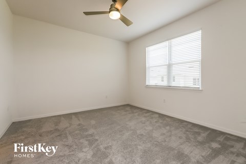 a bedroom with a ceiling fan and a window