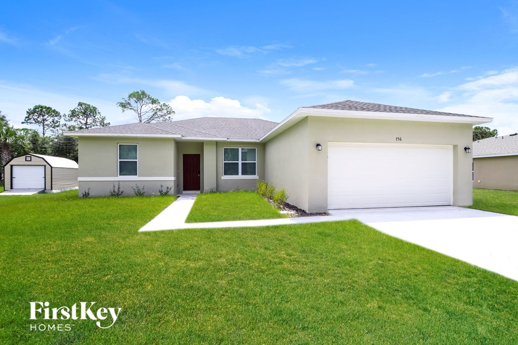 A house with a garage and a driveway in front of it.