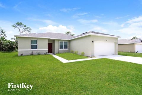 A house with a red door and a white garage door is for sale.