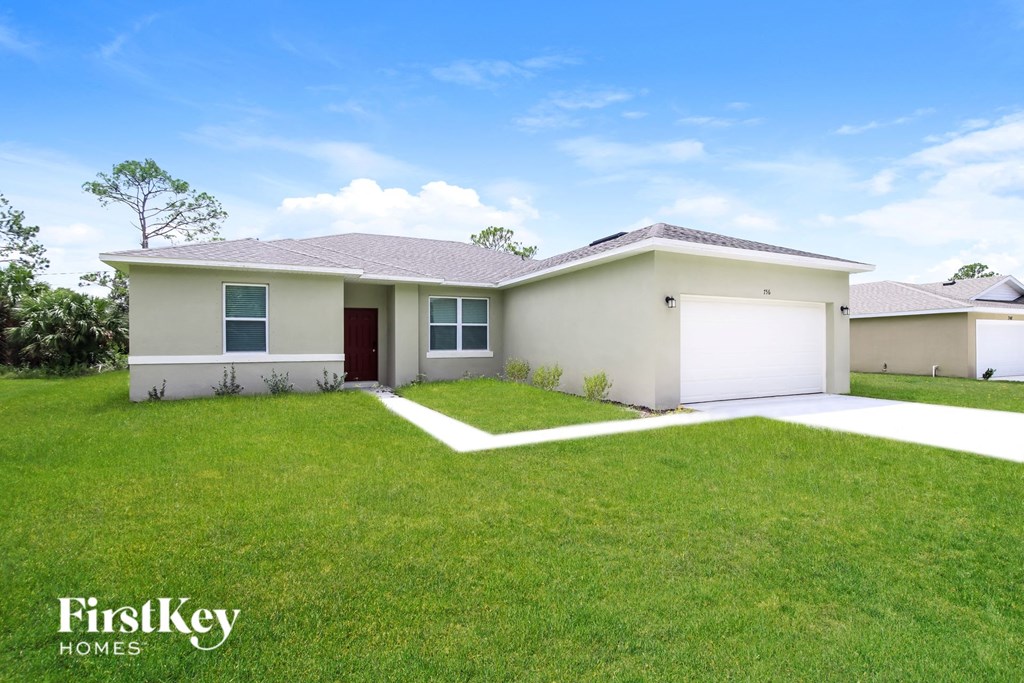A house with a red door and a white garage door is for sale.