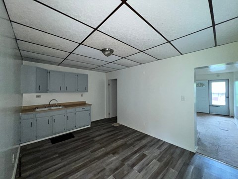 A kitchen with grey cabinets and a wooden countertop.