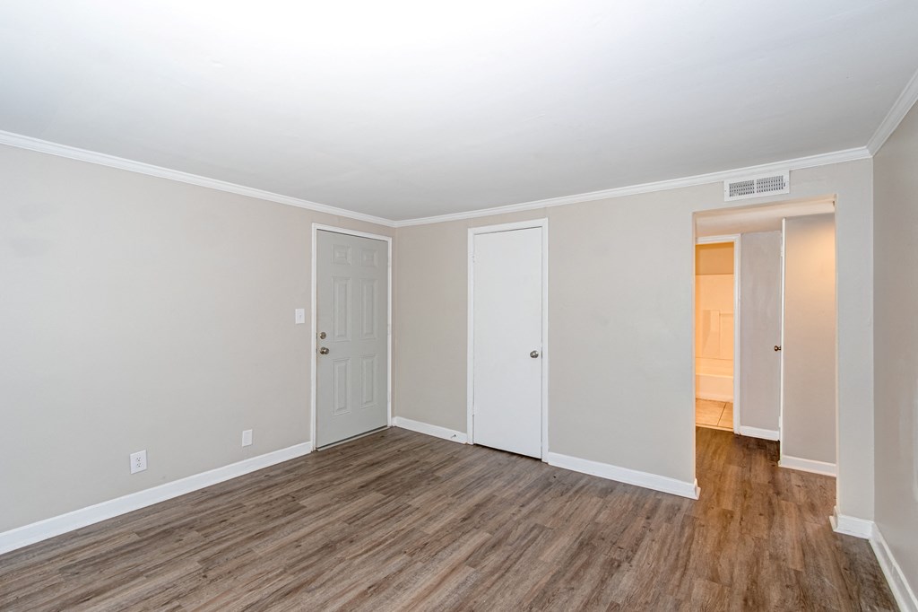 an empty living room with wood flooring and white walls