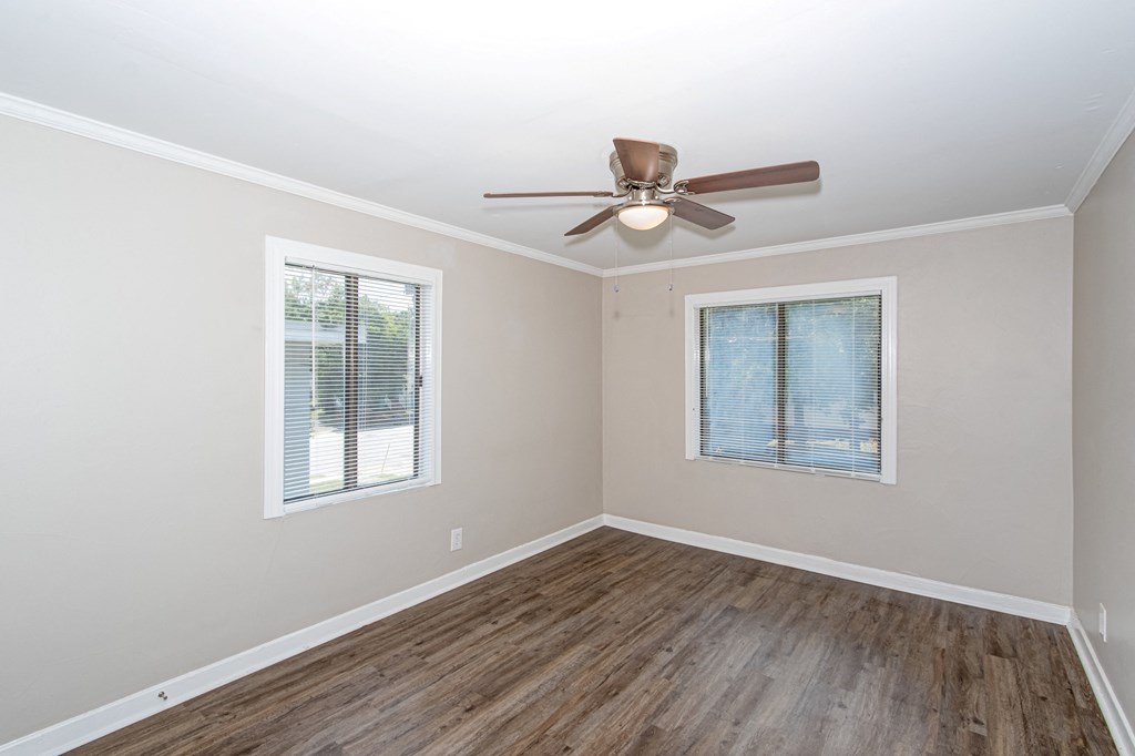 an empty room with a ceiling fan and a window