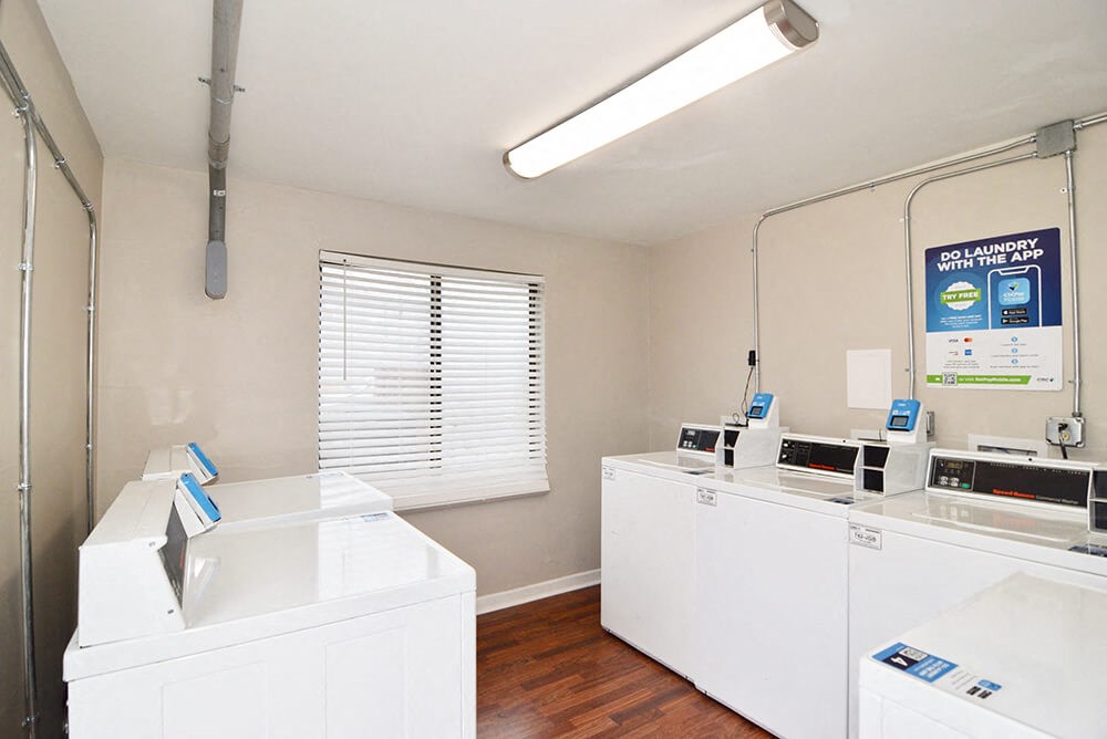 a laundry room with white appliances and a window