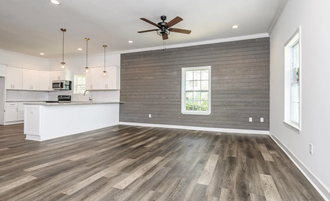 an open kitchen and living room with a ceiling fan