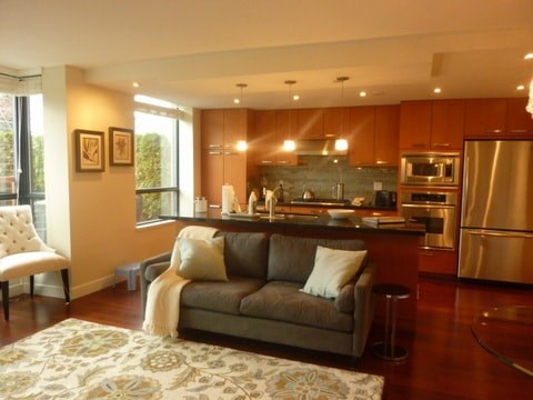 a living room with a couch and a kitchen