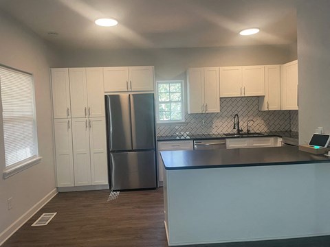 a kitchen with white cabinets and a stainless steel refrigerator
