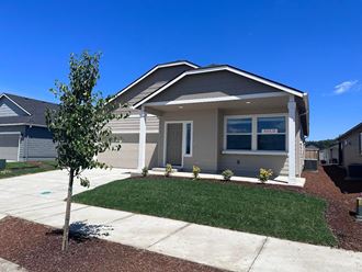 a house with a lawn and a sidewalk in front of it