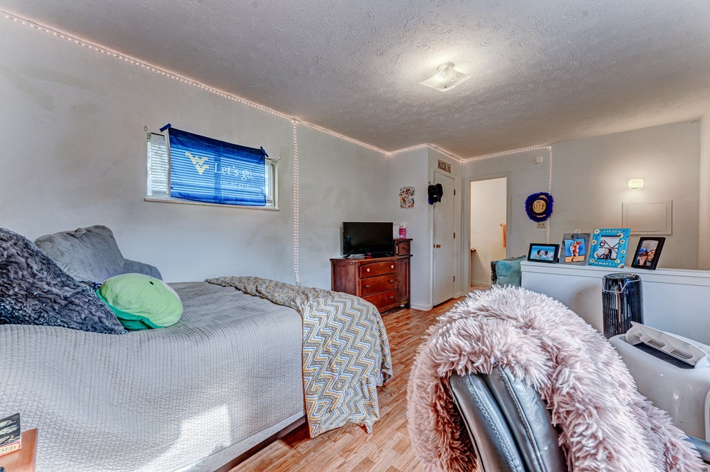 A bedroom with a bed, a chair, and a TV.