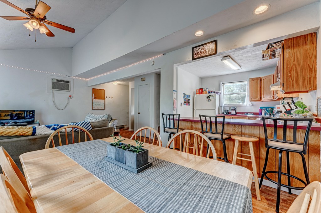 A kitchen with a dining table and chairs.
