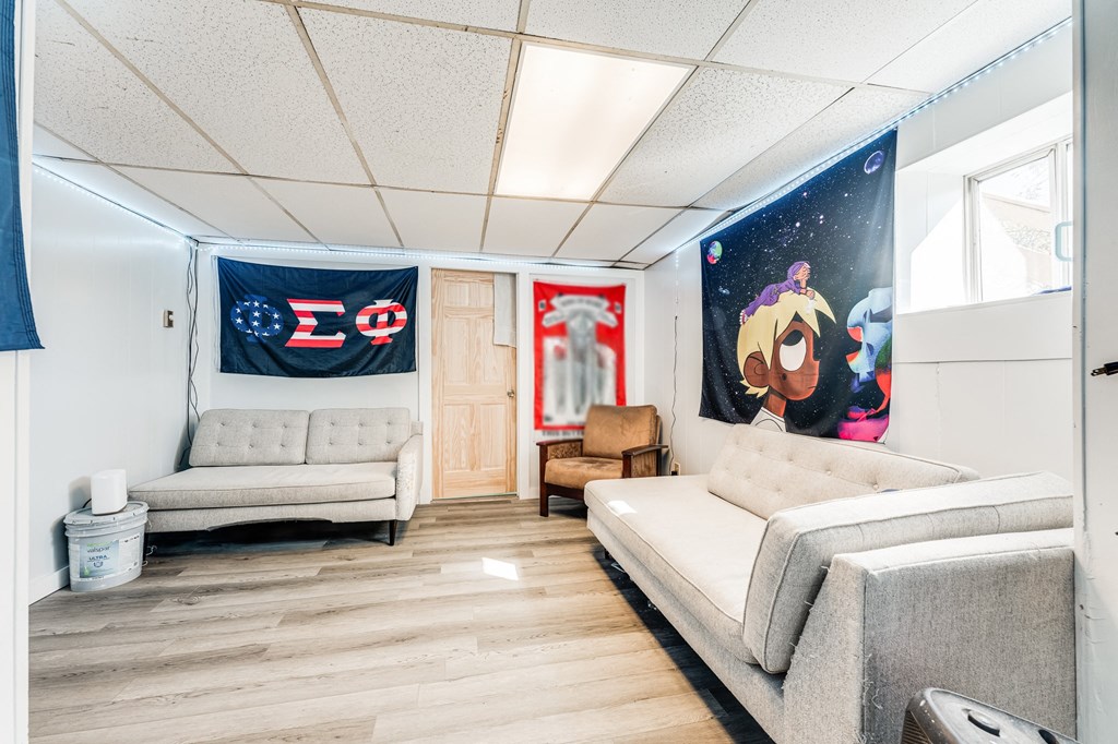 A room with a couch, a bed, and a flag with a Greek letter on it.