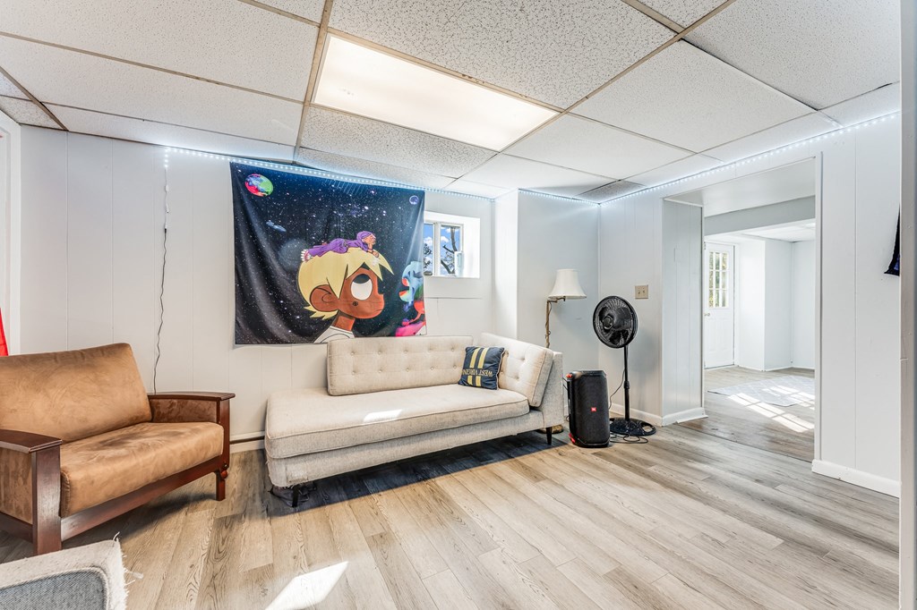 A living room with a couch, chair, and a fan.