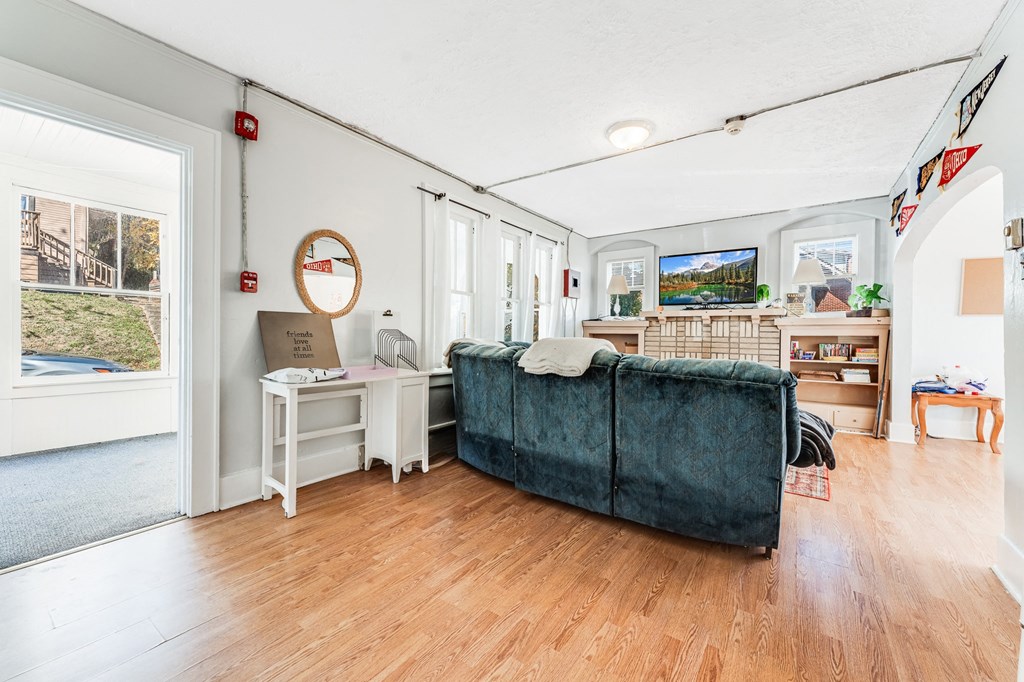 A living room with a blue couch and a white desk.