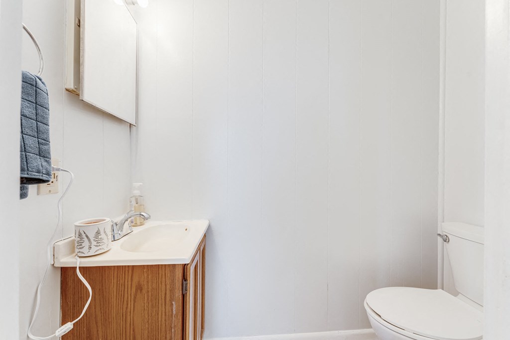 A white toilet sits next to a sink in a small bathroom.