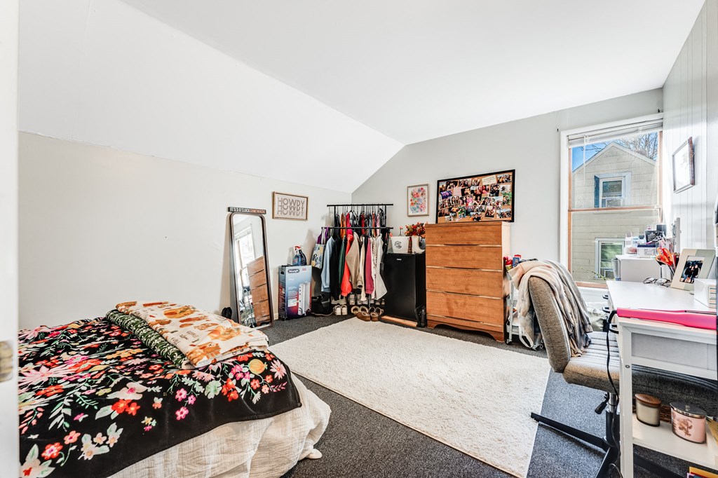 A bedroom with a bed, desk, and chair.