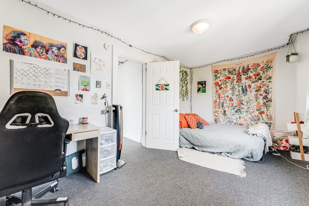 A room with a bed, desk, and chair.