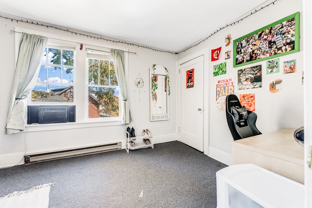 A room with a window, a whiteboard, and pictures on the wall.