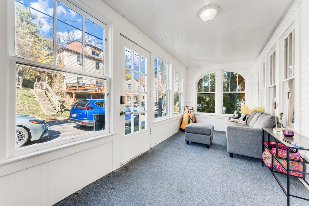 A sunny day in a room with a blue car parked outside.