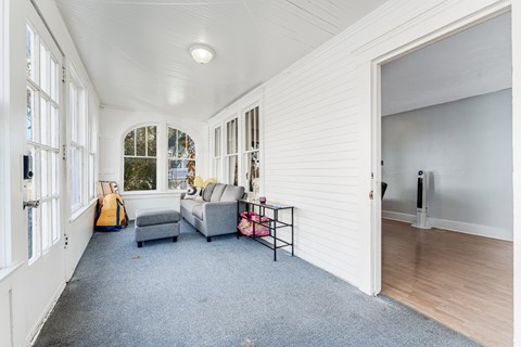 A living room with a grey sofa and a yellow backpack.