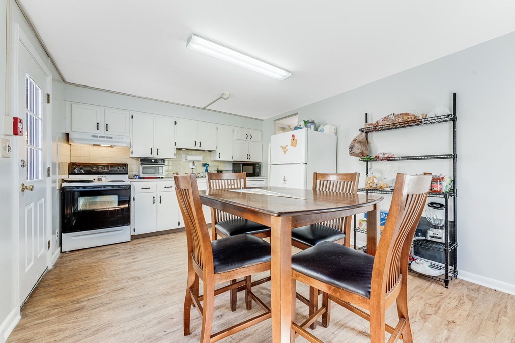 A kitchen with a table and chairs in the foreground.