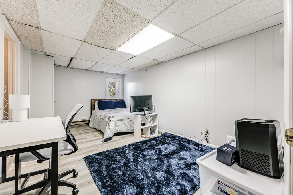 A room with a bed, desk, and chair.