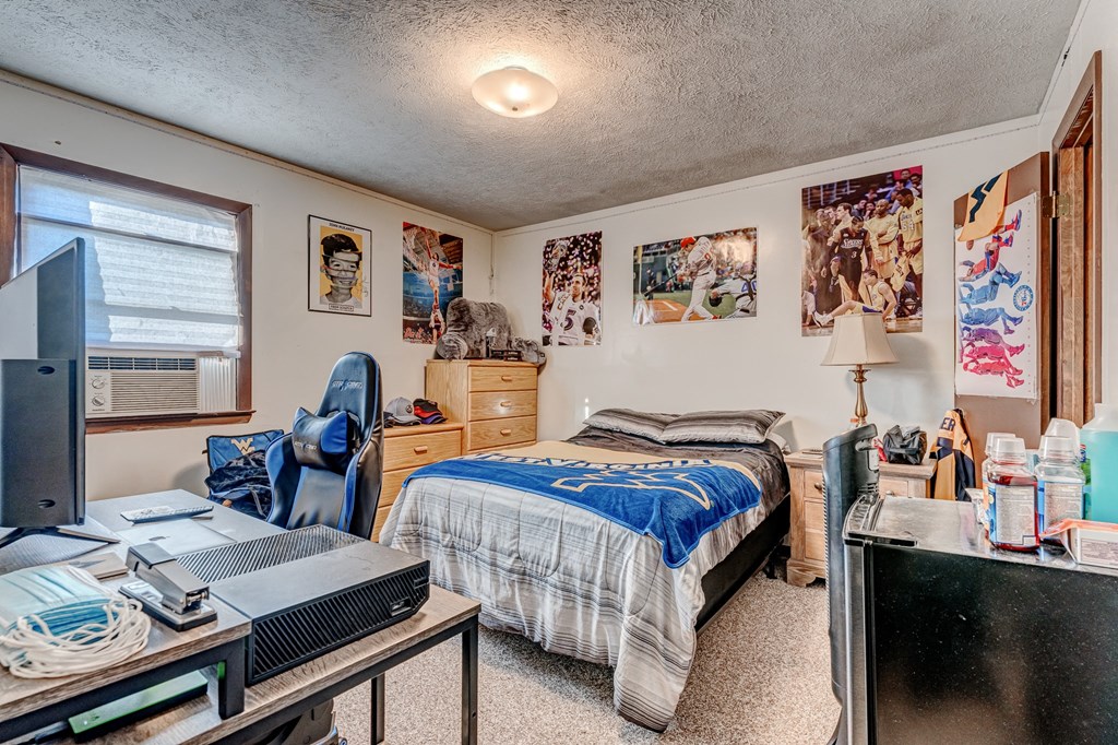 A bedroom with a bed, desk, and chair.
