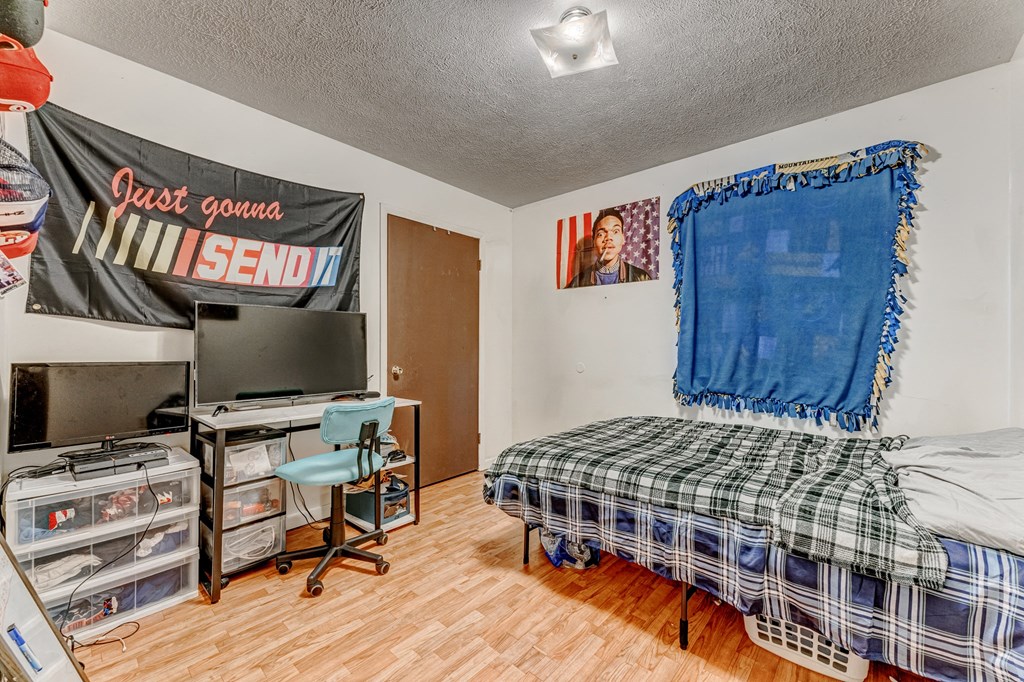 A room with a bed, a desk, and a TV.