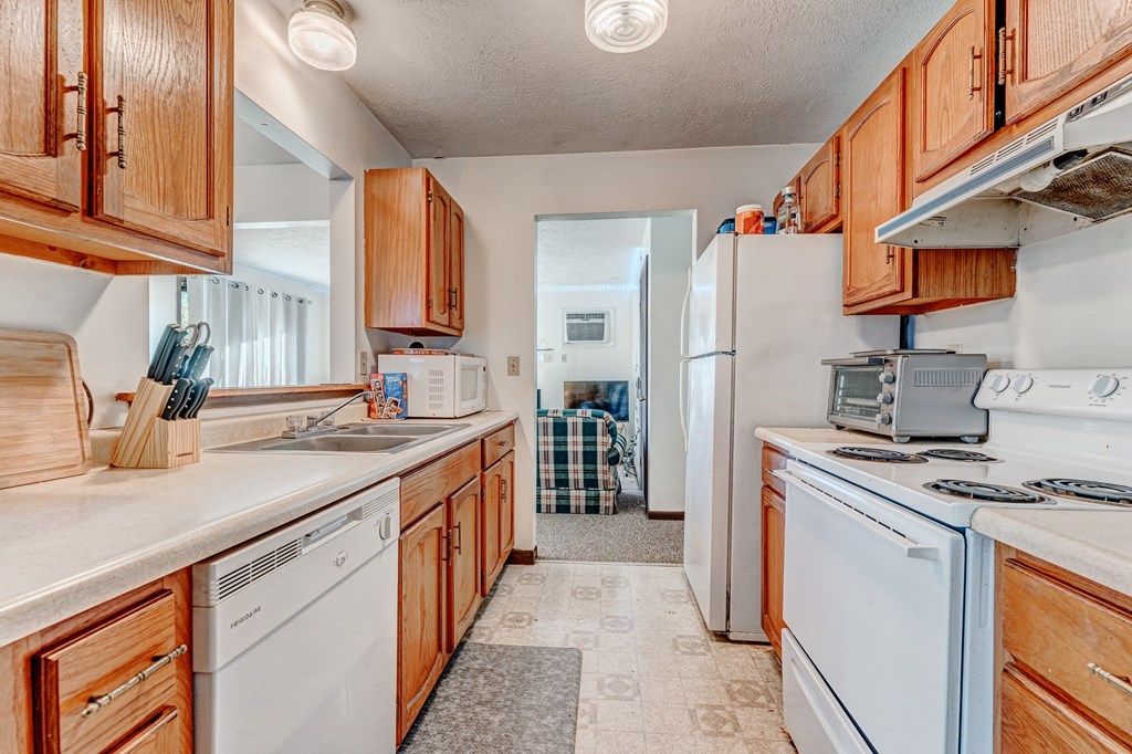 A kitchen with wooden cabinets and white appliances.