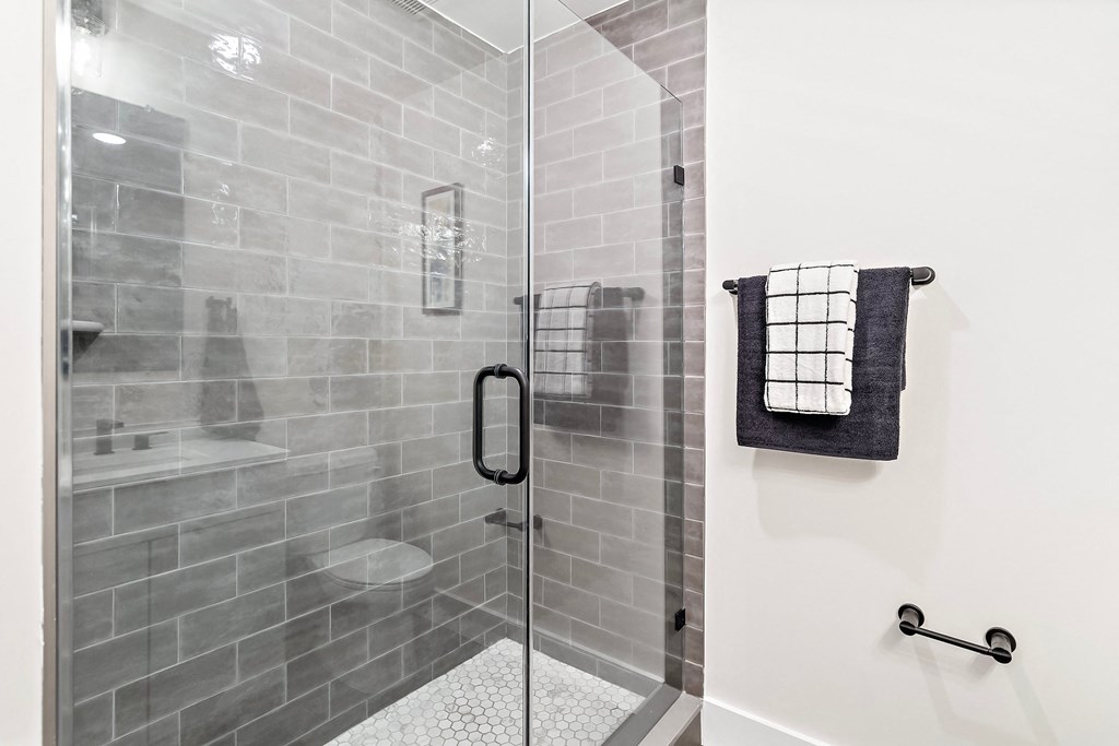 the shower in the bathroom in a 555 waverly unit with a glass door