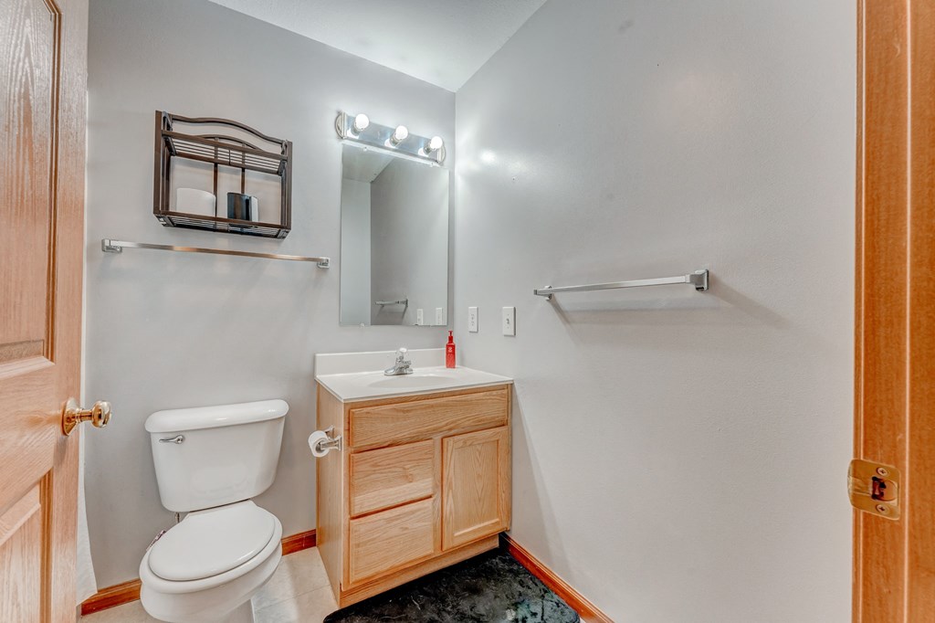 A small bathroom with a toilet, sink, and mirror.
