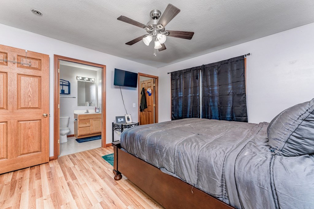 A bedroom with a bed, dresser, and mirror.