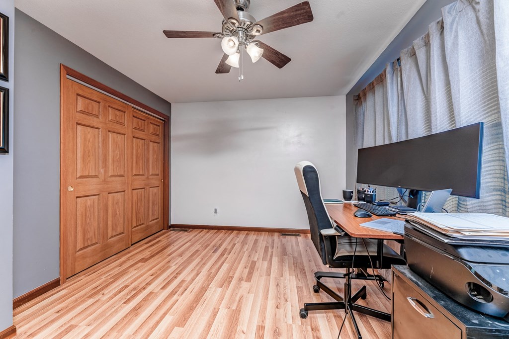 A room with a wooden floor and a ceiling fan.