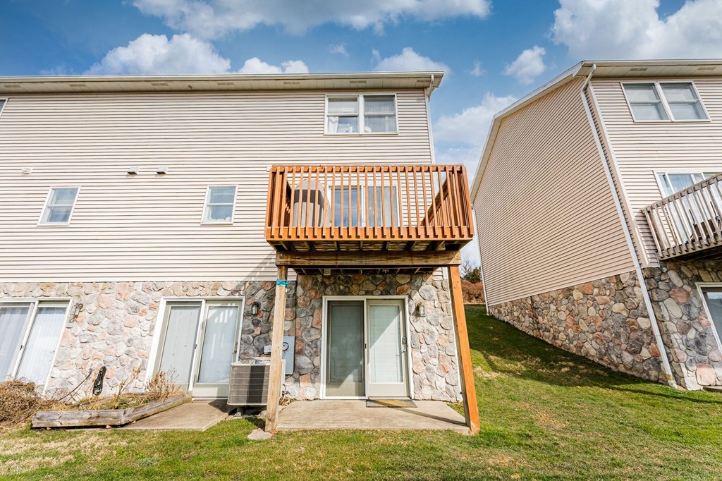 A house with a balcony and a stone wall.
