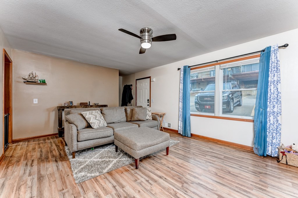 A living room with a grey sofa and a grey ottoman.