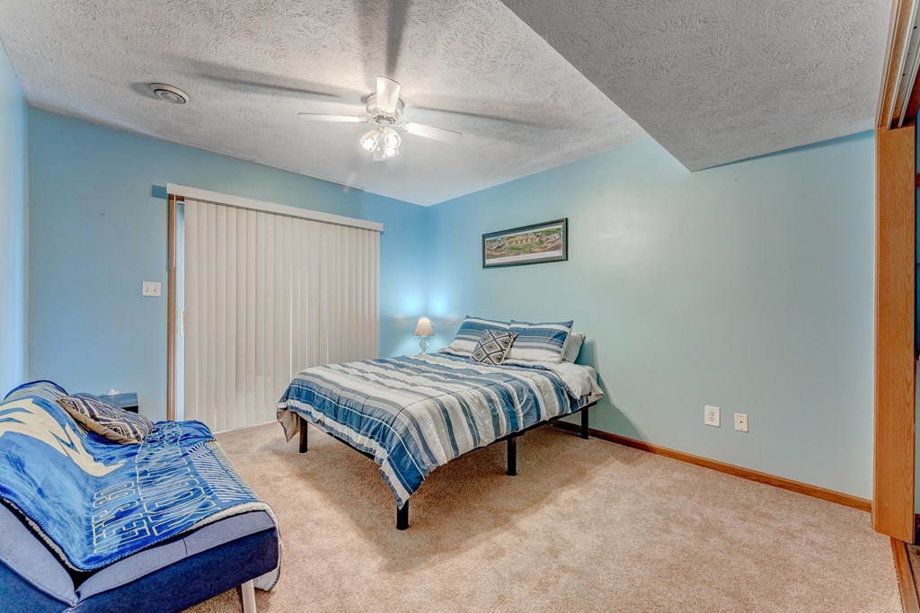 A bedroom with two beds and a ceiling fan.