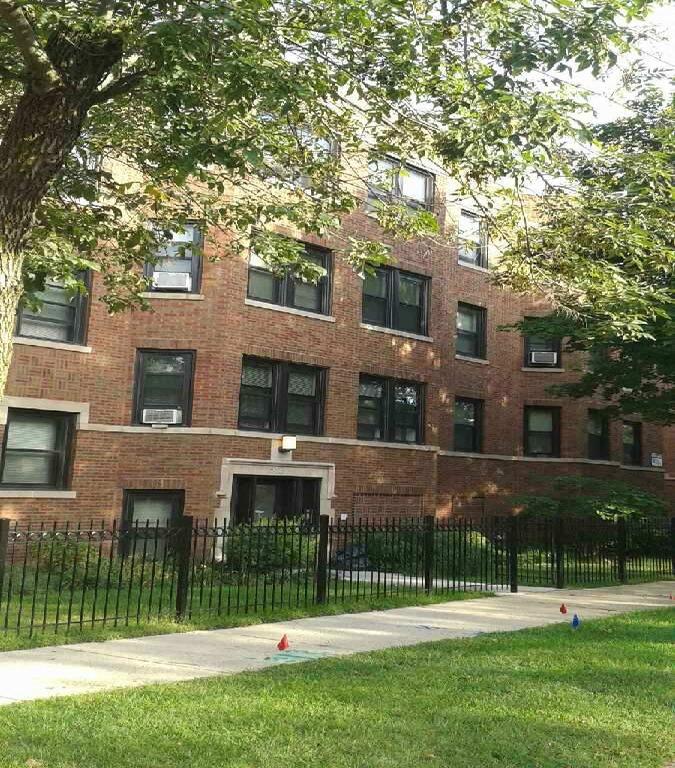 a brick building with a black fence in front of it