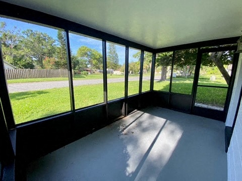 a room with large windows and a view of a yard