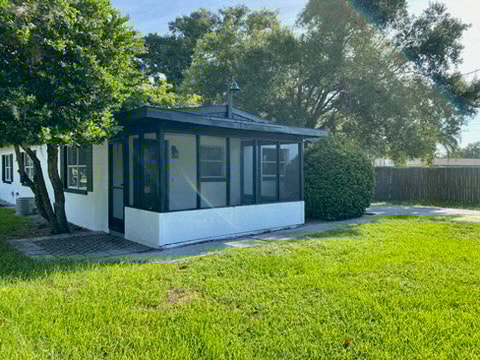 a white gazebo in a yard next to a house