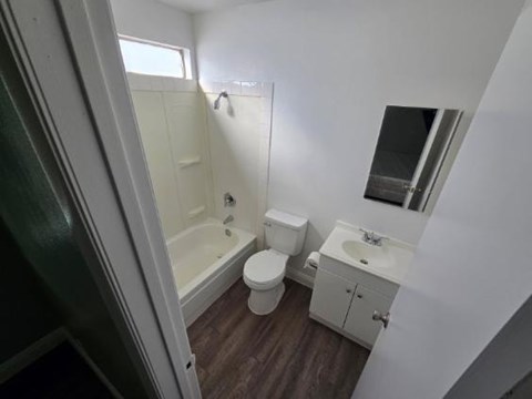 A small bathroom with a toilet, sink and bathtub.
