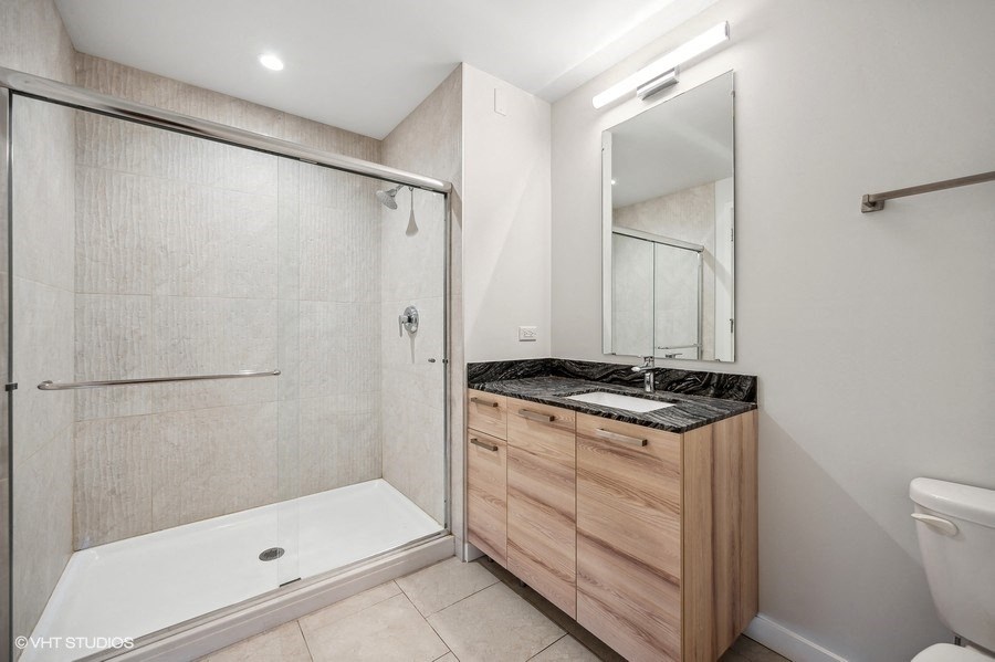 a bathroom with a shower and a sink and a mirror