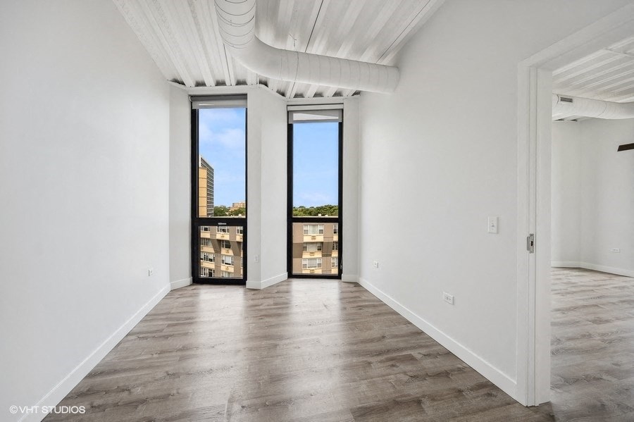 a living room with white walls and a large window