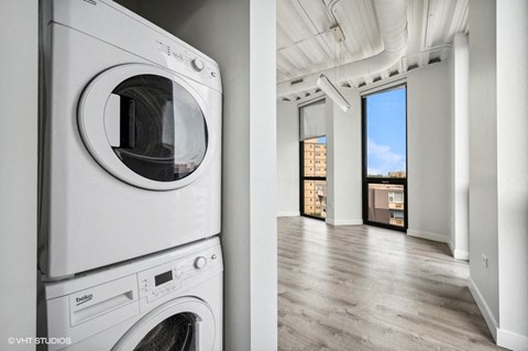 a white washer and dryer in a room next to a window