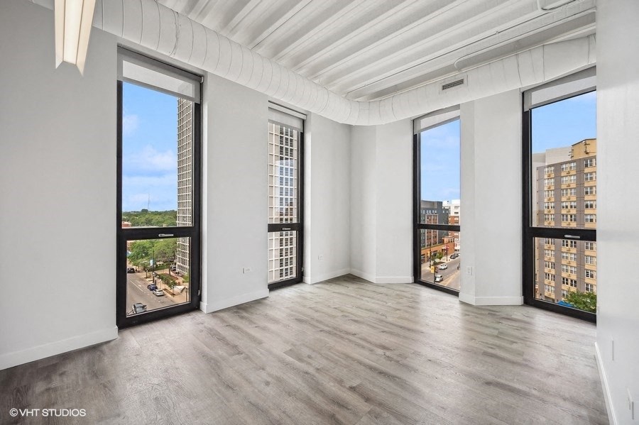 an empty living room with windows and a view of the city