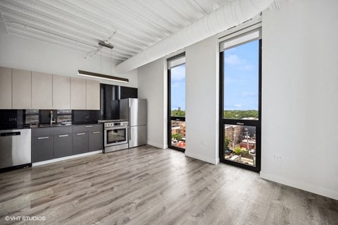 an open living room with a kitchen and a large window