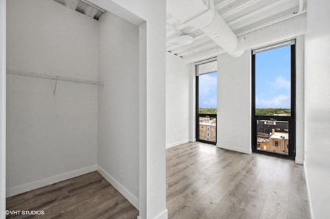 an empty living room with wood floors and a large window